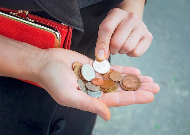 Algunas monedas de euro y un bolso rojo en manos de mujeres