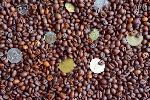 Foto algunas monedas en granos de café.