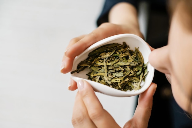 Foto algunas mujeres oliendo hojas de té durante una ceremonia del té chino utensilios de té en las manos vista superior