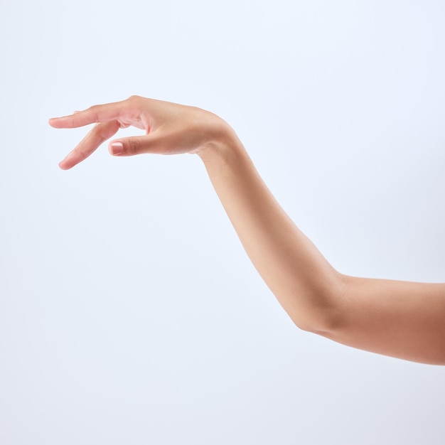 Algunas niñas nacen con purpurina en las venas Foto de estudio de la hermosa mano de una mujer irreconocible contra un fondo gris