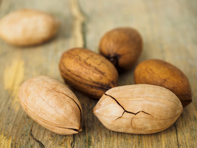 Algunas nueces de necanona en una cáscara agrietada. Nueces sobre una superficie de madera.