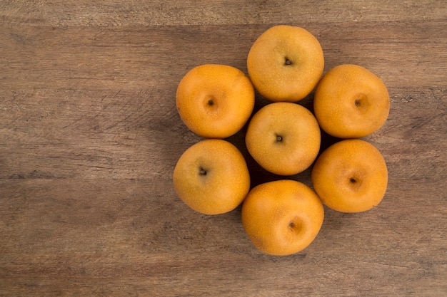 Algunas peras asiáticas sobre una superficie de madera. Frutas frescas