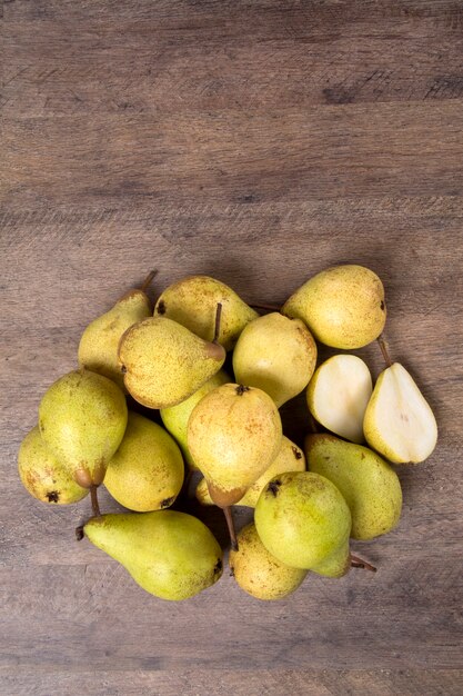 Algunas peras en una canasta sobre una superficie de madera. Frutas frescas