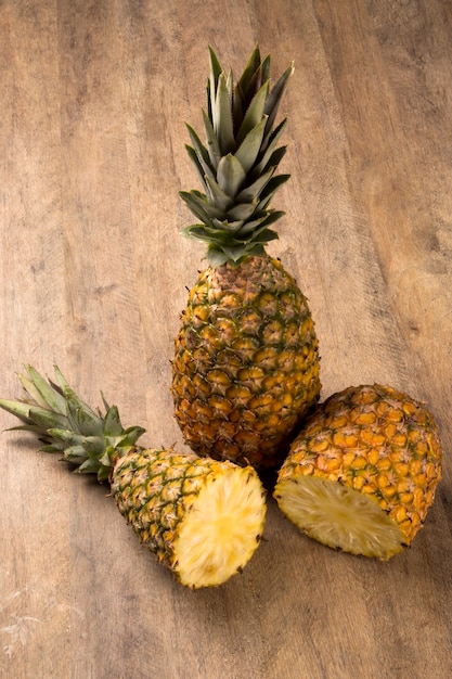 Algunas piñas sobre una mesa de madera. Fruta fresca.