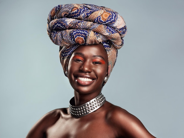 Algunos dicen envoltura para la cabeza, yo digo corona Foto de estudio de una hermosa joven que lleva una envoltura tradicional africana para la cabeza contra un fondo gris