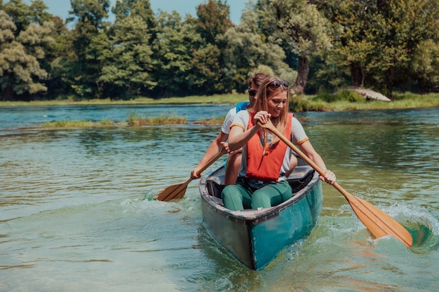 Alguns amigos exploradores aventureiros estão canoando em um rio selvagem cercado pela bela natureza.