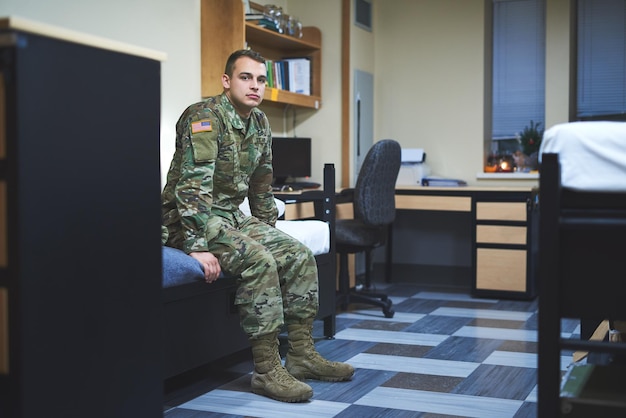 Alguns chamam de dormitório eu chamo de lar foto de um jovem soldado sentado em sua cama nos dormitórios de uma academia militar