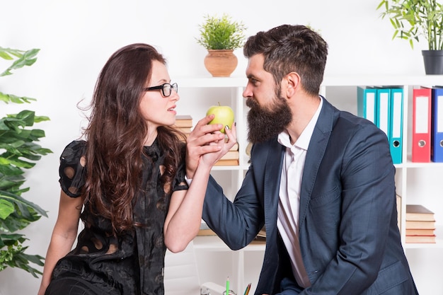 Alguns colegas de trabalho relaxam a pausa para o almoço. compartilhe o almoço com um colega. paquerando colegas. homem barbudo e mulher atraente. conversa de homem e mulher durante a hora do almoço. rumores de escritório. almoço no escritório.