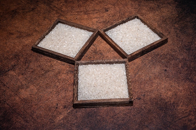 Alguns recipientes quadrados de arroz branco no fundo escuro