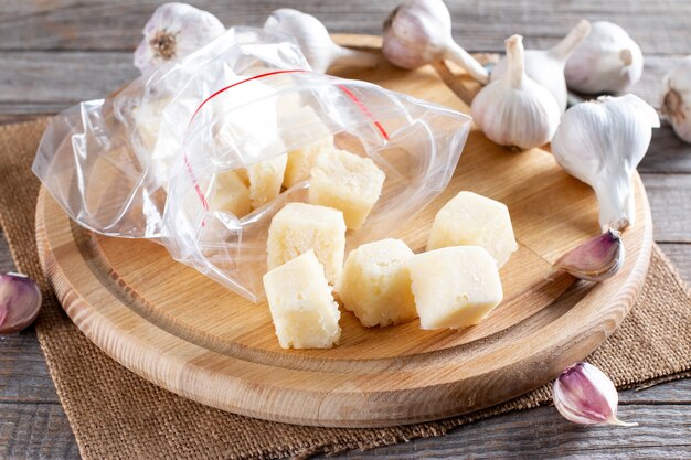 Alho congelado. Alho congelado em um cubo de gelo na mesa. Conceito de alimentos congelados