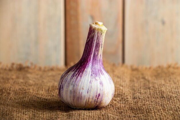 Alho fresco aromático em um fundo de madeira rústico. Ingrediente para cozinhar.