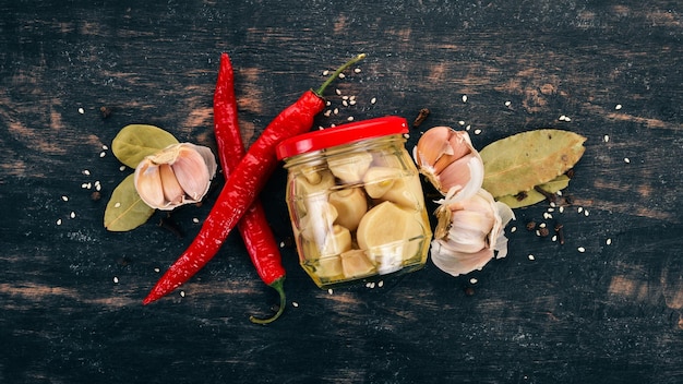 Alho picante marinado Em um fundo preto de madeira Vista superior Copie o espaço para o seu texto