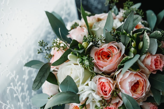 Alianças de casamento com bouquet de noiva deitado na manhã da noiva.