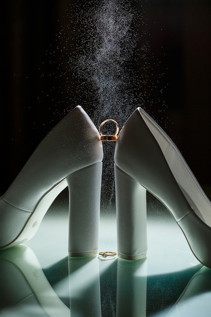 Foto alianza de oro con zapatos de mujer el día de la boda.