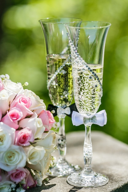 Alianzas de boda con rosas y copas de champagne.