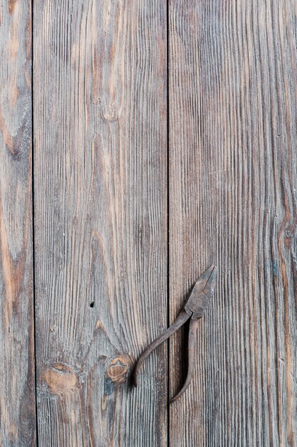 Alicate de aço enferrujado velho em fundo de madeira