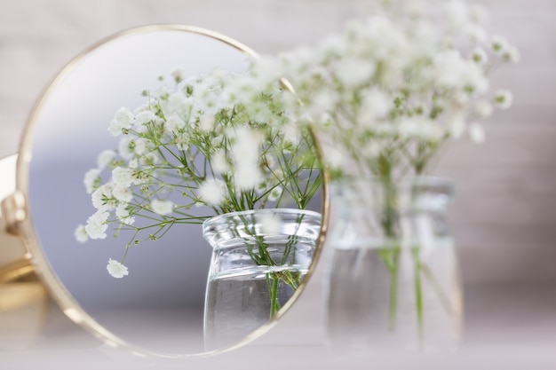 Aliento de bebé rústico Flores de gypsophila blancas secas y espejo sobre la mesa. Hermosas ideas de decoración de bodas e interiores de decoración del hogar de la habitación.