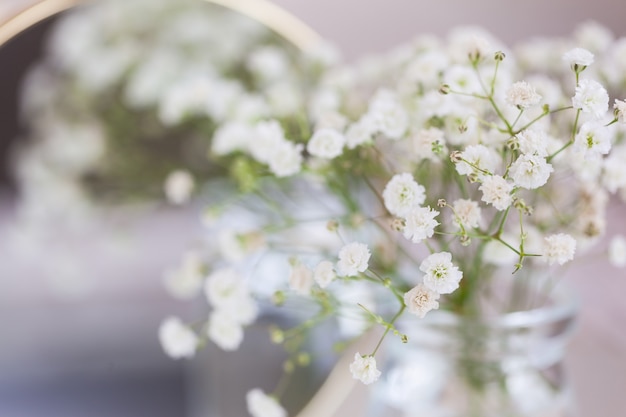 Aliento de bebé rústico Flores de gypsophila blancas secas y espejo sobre la mesa. Hermosas ideas de decoración de bodas e interiores de decoración del hogar de la habitación.