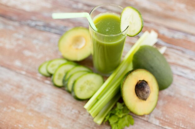 alimentação saudável, alimentos orgânicos e conceito de dieta - close-up de copo de suco verde fresco e legumes na mesa
