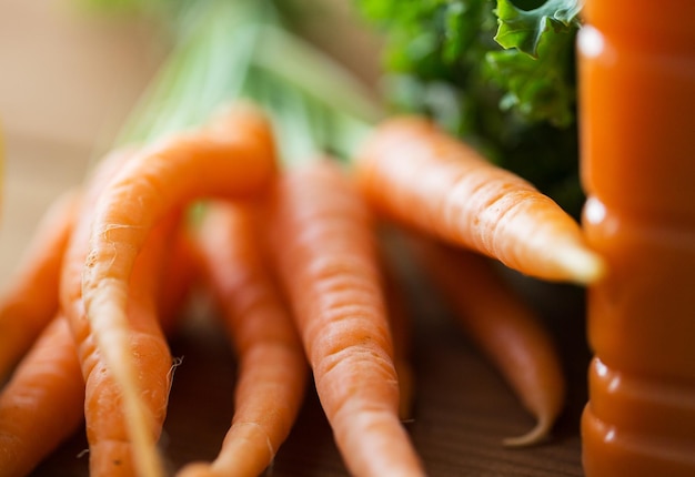 alimentação saudável, comida, dieta e conceito vegetariano - close-up de bando de cenoura na mesa de madeira