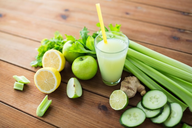 alimentação saudável, comida, dieta e conceito vegetariano - close-up de vidro com suco verde, frutas e legumes na mesa de madeira