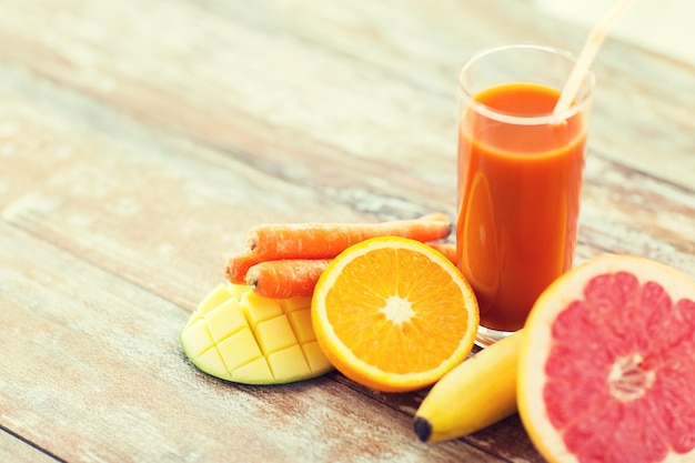 alimentação saudável, comida e conceito de dieta - close-up de copo de suco fresco e frutas na mesa