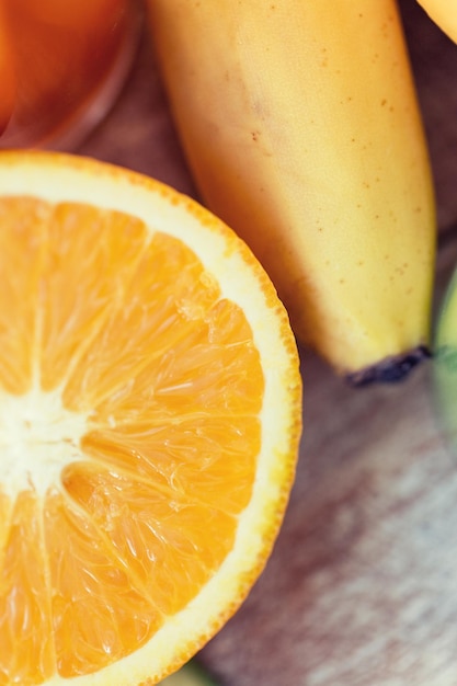 alimentação saudável, comida, frutas e conceito de dieta - close-up de laranja fresca cortada suculenta e banana na mesa