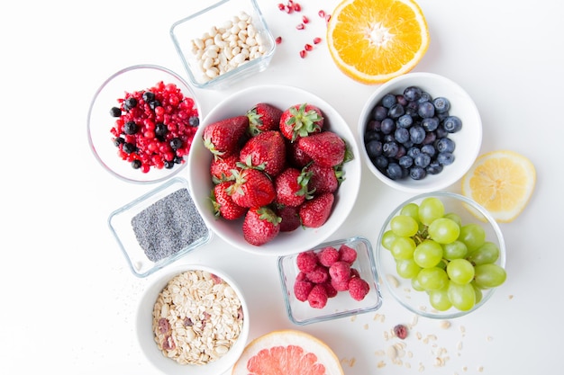 alimentação saudável, dieta, comida vegetariana e conceito de pessoas - close-up de frutas e bagas em tigela na mesa