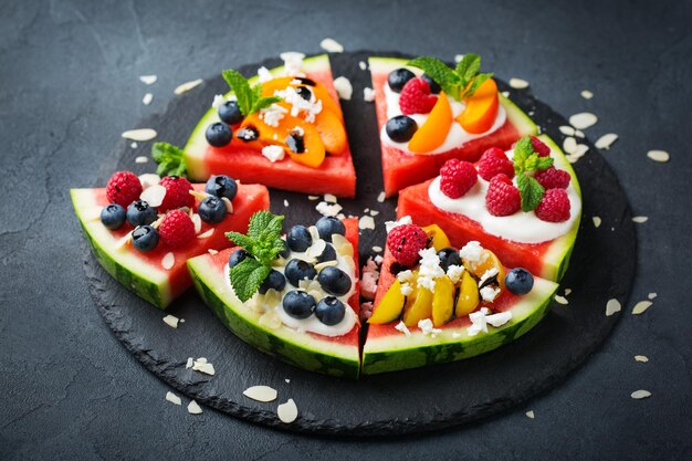 Alimentação saudável, dieta e nutrição, conceito sazonal de verão, pizza de melancia com frutas, iogurte, queijo feta, em uma mesa