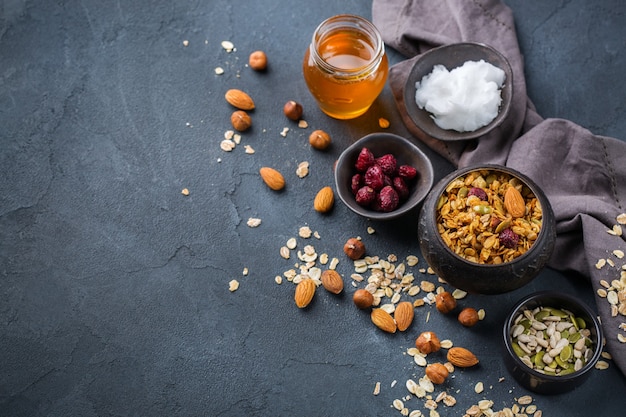 Alimentação saudável, dieta e nutrição, fitness, alimentação equilibrada, conceito de café da manhã. muesli de granola caseiro com ingredientes em uma mesa. copie o fundo do espaço