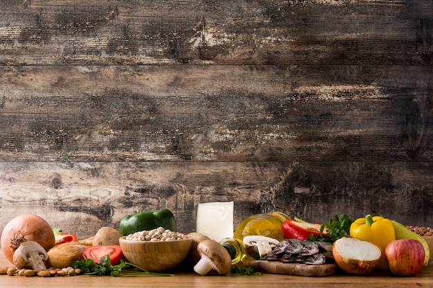Alimentação saudável. Dieta mediterrânea. Frutas, legumes, grãos, azeite de oliva e peixe na mesa de madeira. Copyspace