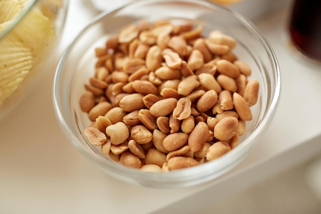 alimentação saudável, dieta protéica e conceito de comida - close-up de amendoim torrado na tigela de vidro na mesa