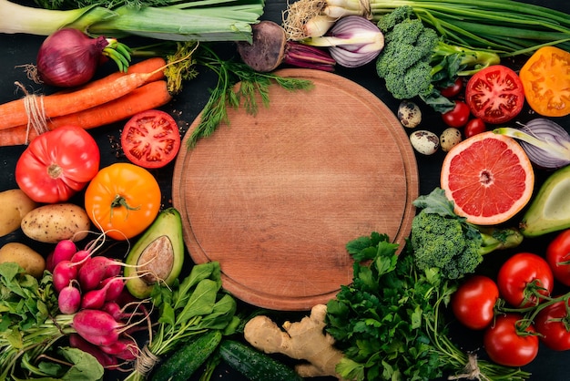 Alimentação saudável Vegetais e frutas sobre um fundo de madeira preta Vista superior Espaço de cópia