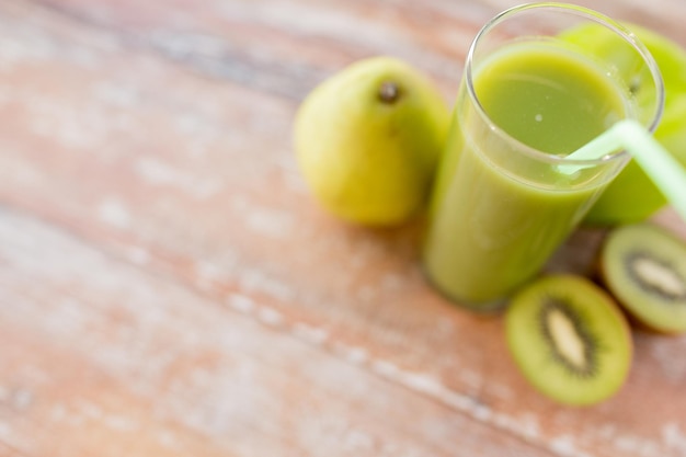 alimentación saludable, alimentos orgánicos y concepto de dieta - cierre de jugo verde fresco y frutas en la mesa