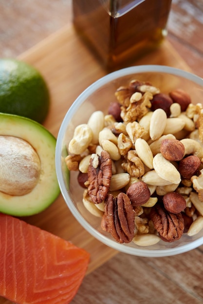 alimentación saludable, alimentos proteicos, dieta y concepto culinario: cierre de la mezcla de nueces en un recipiente de vidrio sobre la mesa