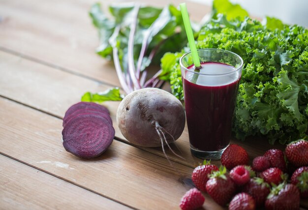 alimentación saludable, comida, dieta y concepto vegetariano - vaso de jugo de remolacha, frutas y verduras en una mesa de madera