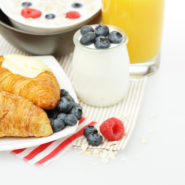 Alimentación saludable: desayuno con croissant, bayas y jugo de naranja