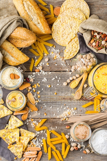 Foto alimentación saludable, dieta, concepto de comida equilibrada. surtido de harina y alimentos sin gluten, almendras, maíz, arroz en una mesa de madera. vista superior de fondo plano laico