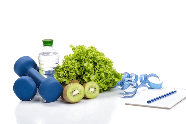 Foto alimentación saludable, dieta y pérdida de peso, desintoxicación. mancuernas, kiwi y una botella de agua