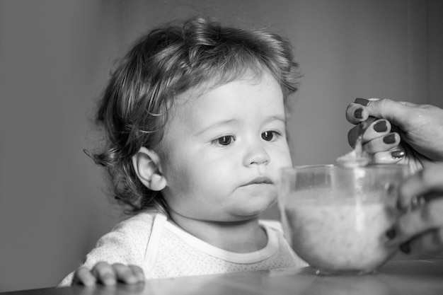 Alimentando a la madre del bebé alimentando a su hijo con puré de frutas nutrición saludable para niños