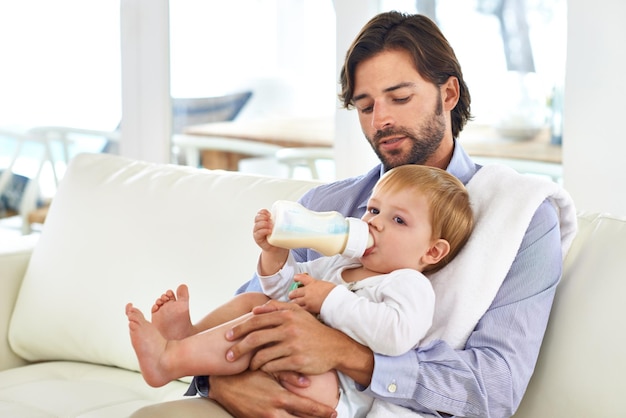 Alimentando seu bebê Vista cortada de um pai dando uma mamadeira a seu filho