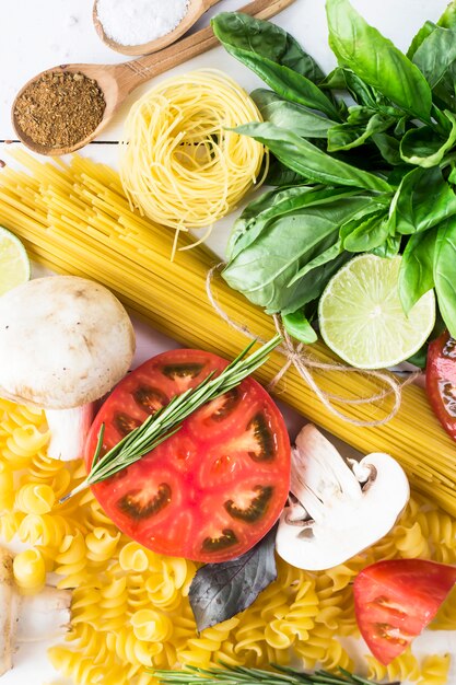 Alimento para cocinar - pasta, albahaca, verduras, lima y especias