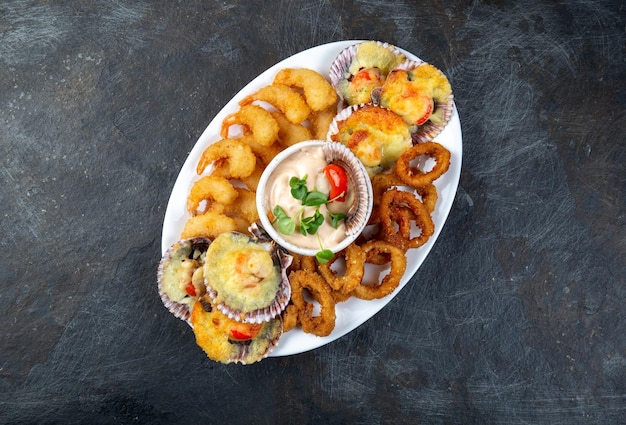 ALIMENTO PERUVIANO Piqueo caliente Prato de frutos do mar quentes camarões fritos anéis de lulas e vieiras assadas com molho