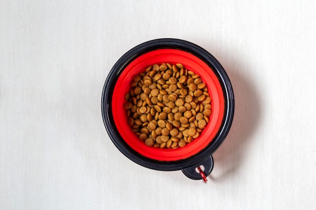 Alimentos para animales en maceta roja en el suelo.