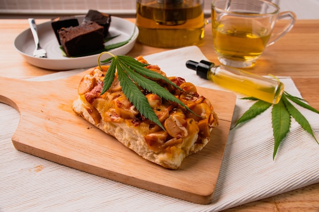 Alimentos y bebidas y aceite de cannabis en la mesa del comedor. Concepto de medicina alternativa.