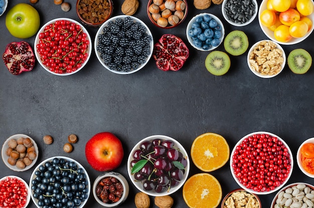 Alimentos com alto teor de antioxidantes bagas nozes frutas fundo de concreto preto copiar espaço