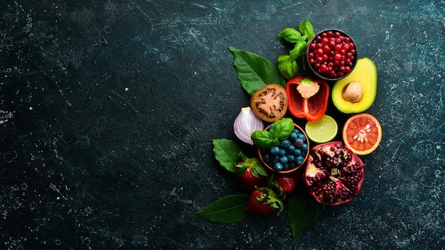 Alimentos Conjunto de verduras y frutas frescas sobre un fondo de piedra negra Alimentos orgánicos Vista superior Espacio libre para su texto