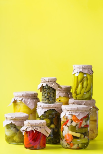 Alimentos en conserva y fermentados. Surtido de tarros caseros con variedad de verduras en escabeche y marinadas sobre una mesa. Limpieza, economía doméstica, preservación de la cosecha