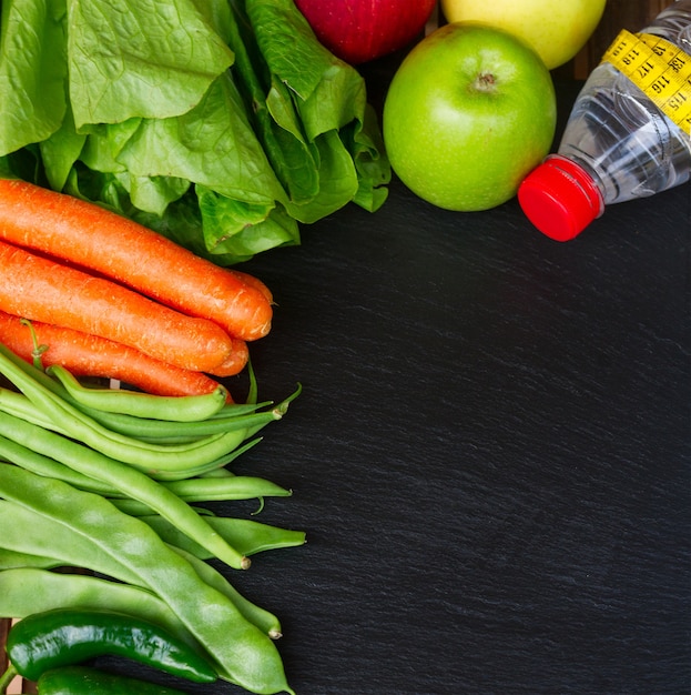 Alimentos crudos saludables y agua en la mesa con espacio de copia, vista superior