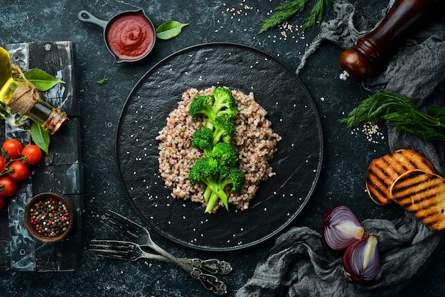 Alimentos dietéticos saludables Trigo sarraceno hervido y brócoli En un plato de piedra negra Vista superior